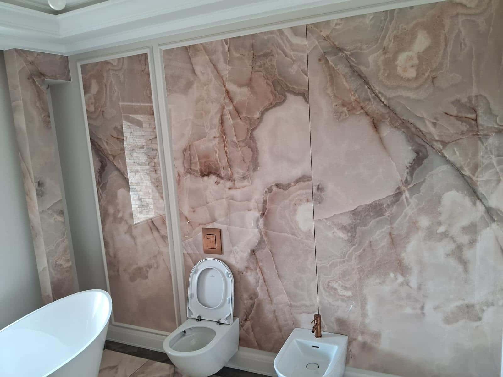Baie placată integral cu plăci mari cu aspect de onix roz