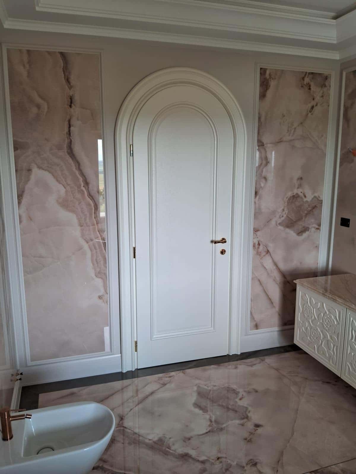 Baie cu ușă arcuită, pereți și pardoseală cu aspect de onix roz