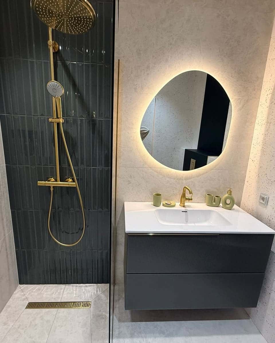 Duș cu perete din plăci verzi înguste, baterie aurie și oglindă luminată