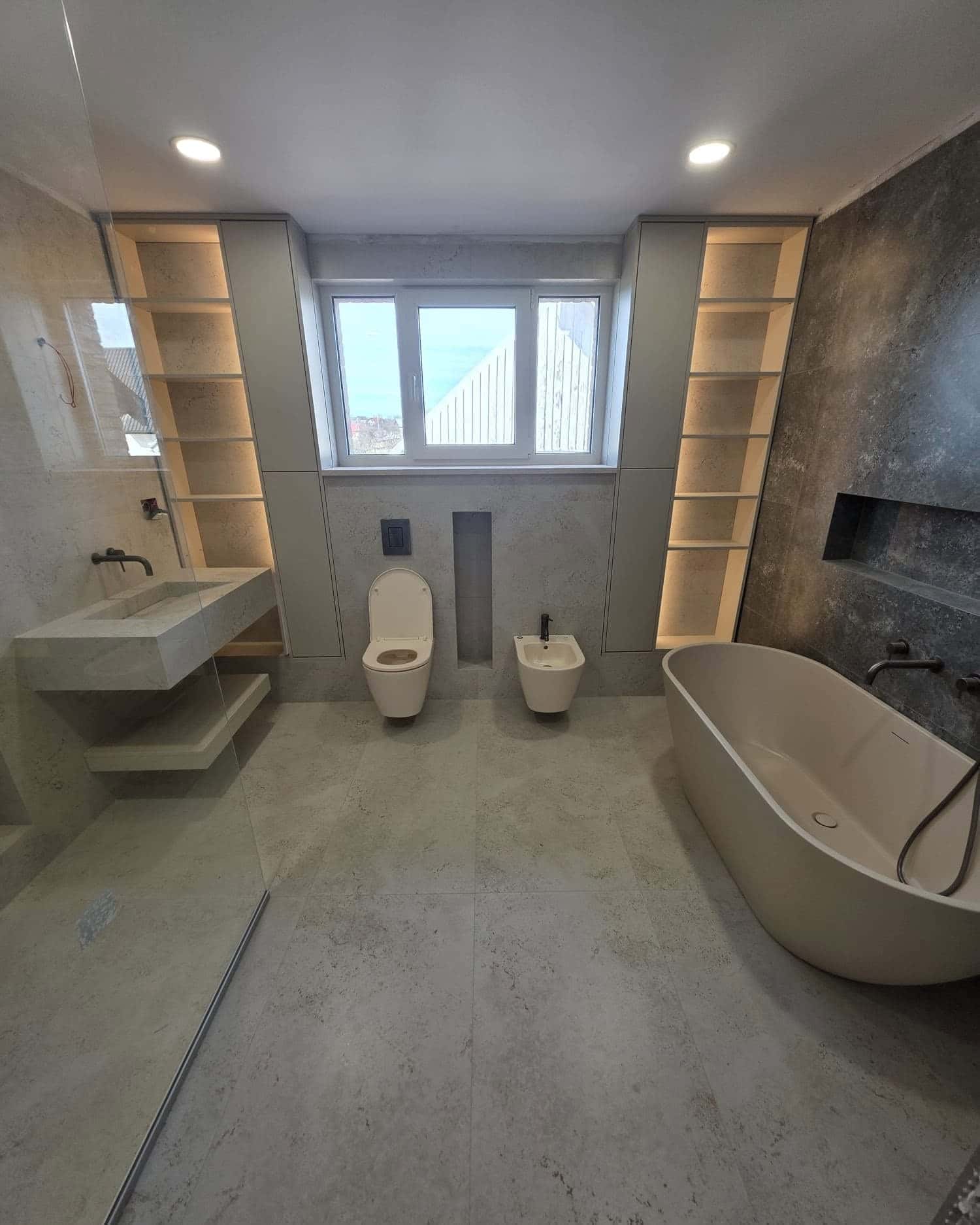 Baie la mansardă cu cadă liberă, nișe luminate și plăci cu aspect de piatră